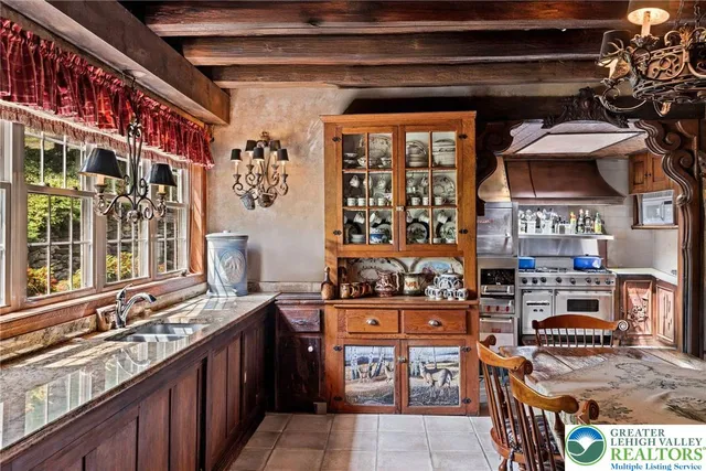 a view of a dining room with furniture a chandelier and large windows