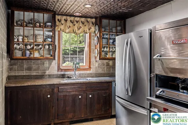 a kitchen with a sink a refrigerator and wooden cabinets