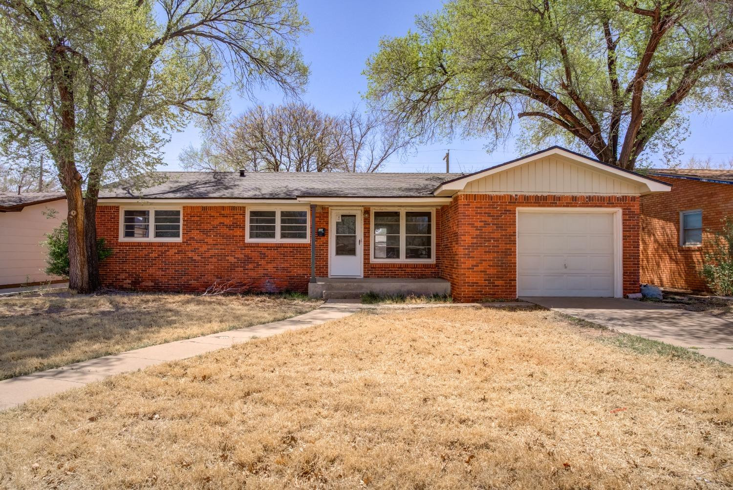 3011 44th Street Lubbock, TX 79413 - Photo 1 of 19 a front view of a house with a yard and garage