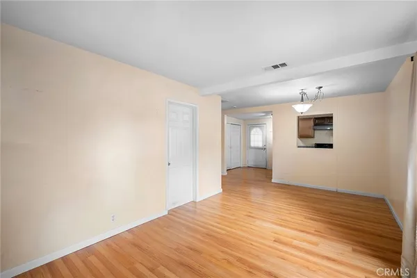 a view of a big room with wooden floor and windows