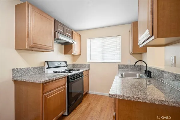a kitchen with stainless steel appliances granite countertop a sink stove and cabinets