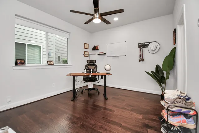 a workspace with furniture a potted plant and wooden floor