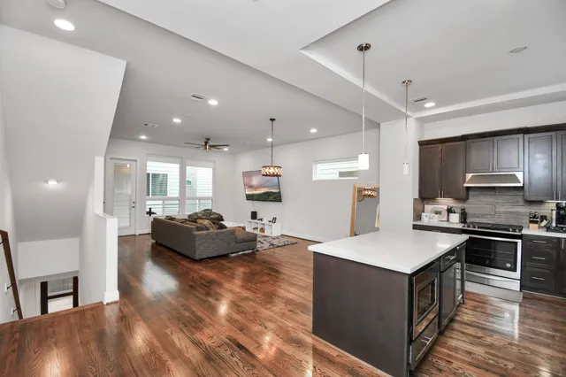 a kitchen with kitchen island a stove a sink a refrigerator and chairs