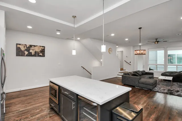 a large kitchen with stainless steel appliances a stove a sink dishwasher and a dining table with wooden floor