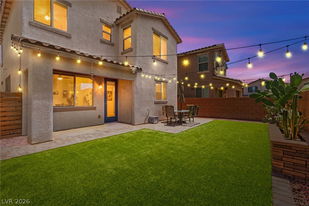 6435 Point Isabel Way Las Vegas, NV 89122 - Photo 21 of 57 Illuminated patio and lush artificial turf create an inviting outdoor oasis for evening enjoyment.