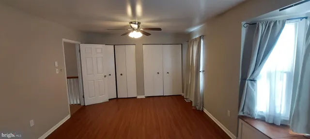 a view of a hallway with wooden floor and chandelier