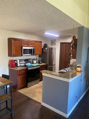 a kitchen with kitchen island granite countertop stainless steel appliances and a sink