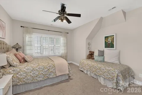 a bedroom with a large bed and a chandelier