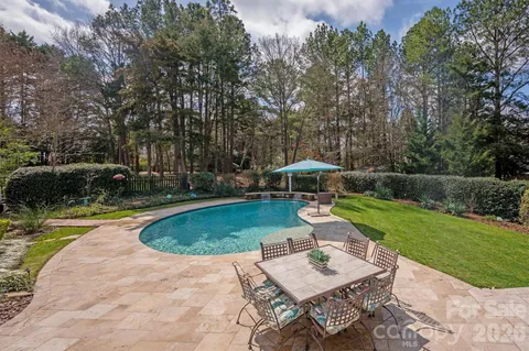 a view of a swimming pool with lawn chairs under an umbrella