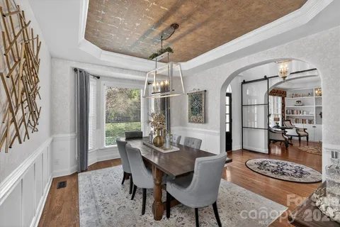 a dining room with furniture a chandelier and wooden floor