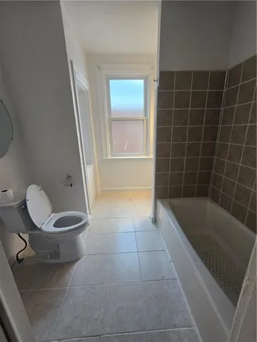 a bathroom with a toilet and a mirror