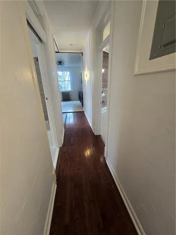 a view of a hallway with wooden floor and staircase