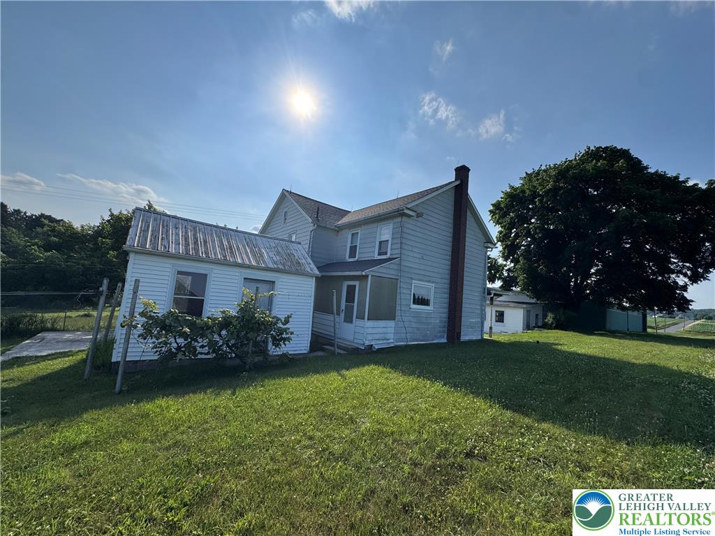 868 Catawissa Road Tamaqua, PA 18252 - Photo 9 of 67 A classic farmhouse with ample green space under a bright summer sky.