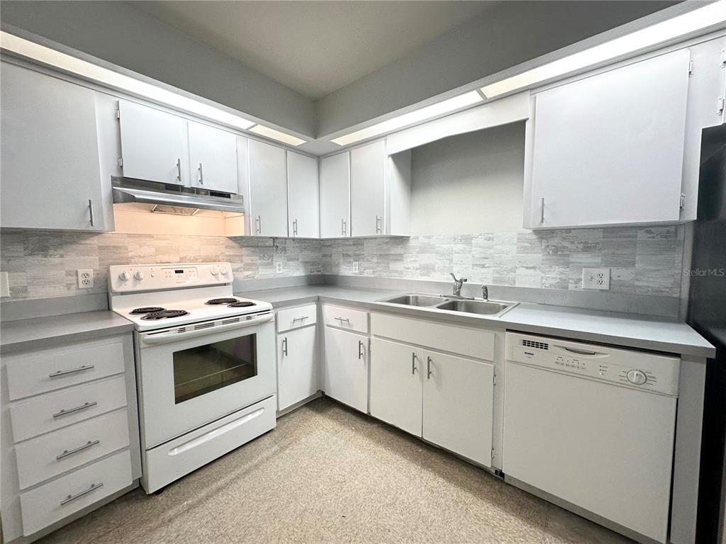 101 Lake Hunter Drive, Unit 15 Lakeland, FL 33803 - Photo 3 of 11 a kitchen with granite countertop white cabinets and white appliances
