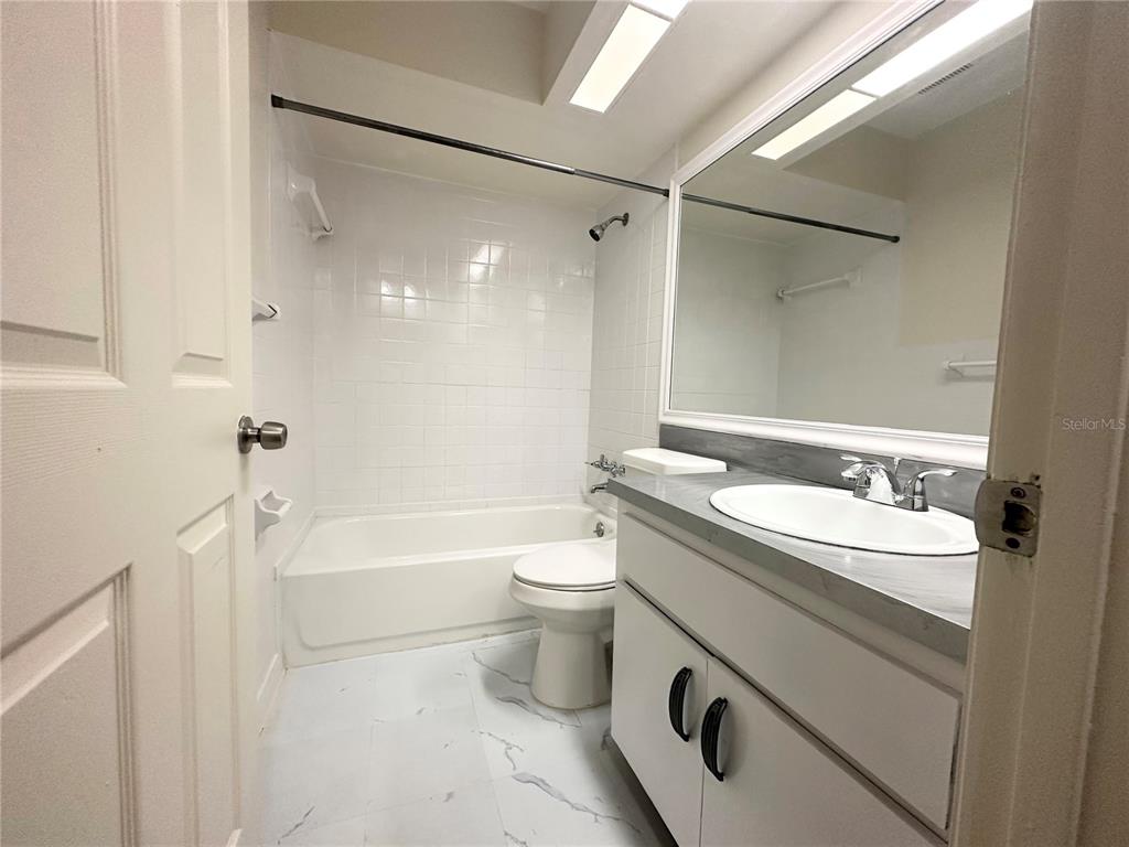 101 Lake Hunter Drive, Unit 15 Lakeland, FL 33803 - Photo 10 of 11 a bathroom with a double vanity sink toilet mirror and shower