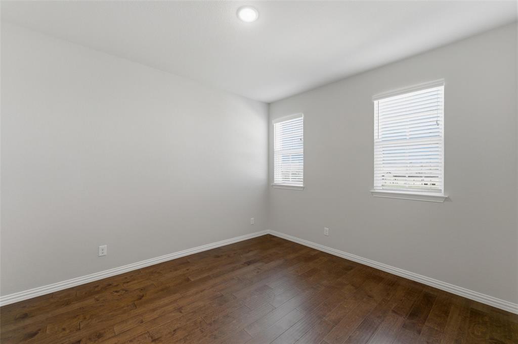 7437 Aniston Way Godley, TX 76044 - Photo 5 of 23 an empty room with wooden floor and windows