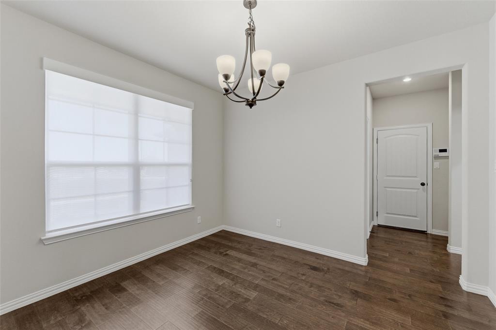 7437 Aniston Way Godley, TX 76044 - Photo 6 of 23 wooden floor in an empty room with a window