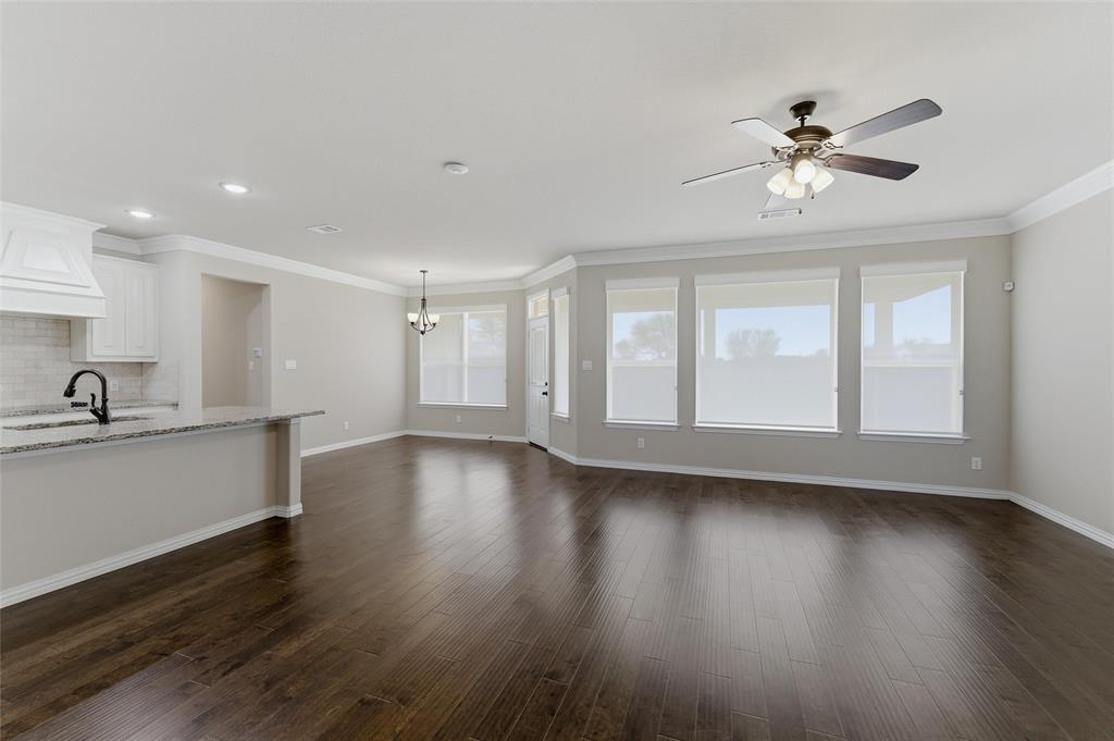 7437 Aniston Way Godley, TX 76044 - Photo 7 of 23 a view of an empty room with wooden floor and a window