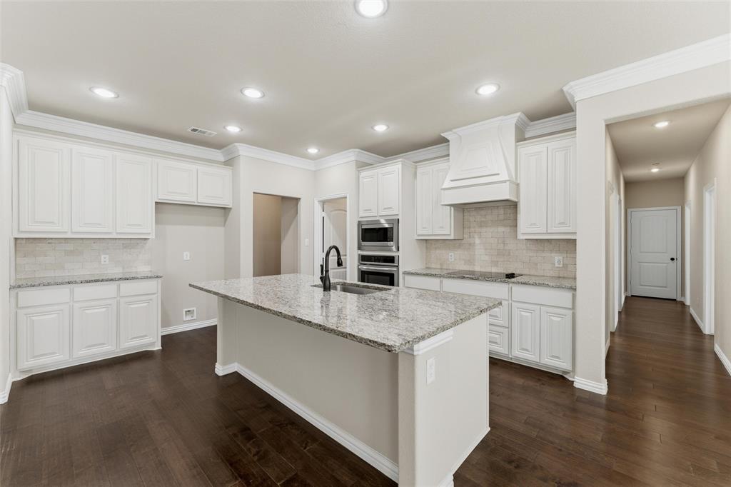 7437 Aniston Way Godley, TX 76044 - Photo 9 of 23 a large kitchen with cabinets stainless steel appliances