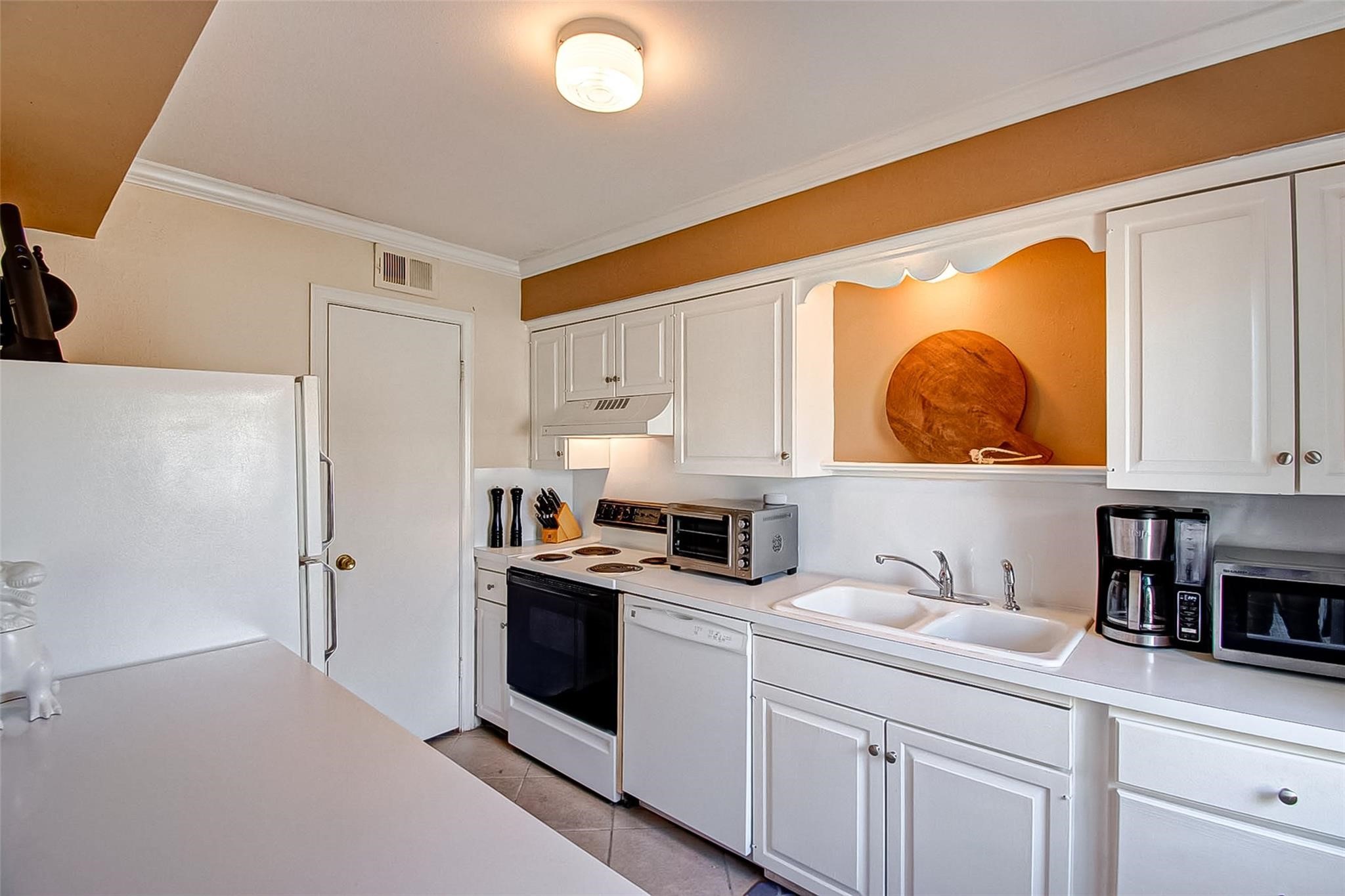 6332 Chevy Chase Drive, Unit 16 Houston, TX 77057 - Photo 11 of 32 a kitchen with stainless steel appliances a sink a stove and white cabinets