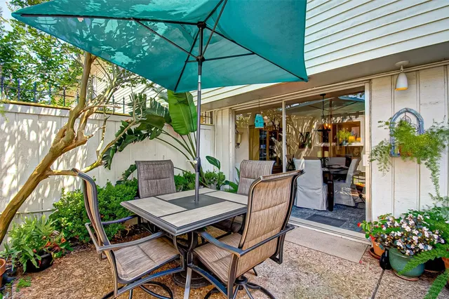 a view of a patio with table and chairs under an umbrella
