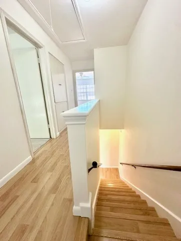 a view of a bedroom with wooden floor and front door