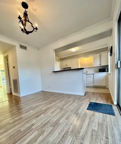 a view of empty room with wooden floor and windows
