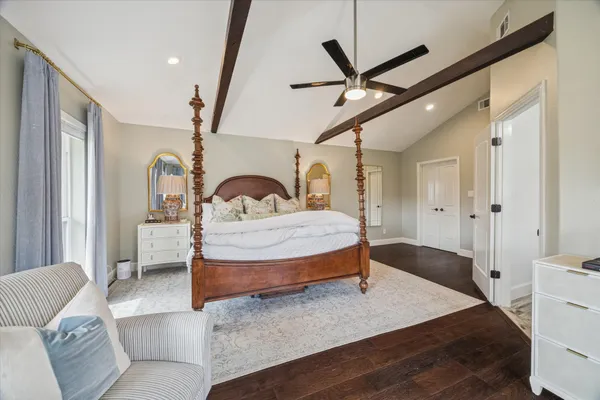 a bedroom with a bed a ceiling fan and a dresser