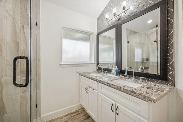 a bathroom with a granite countertop sink and a mirror