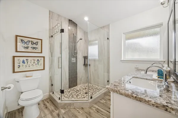 a bathroom with a granite countertop sink toilet and shower