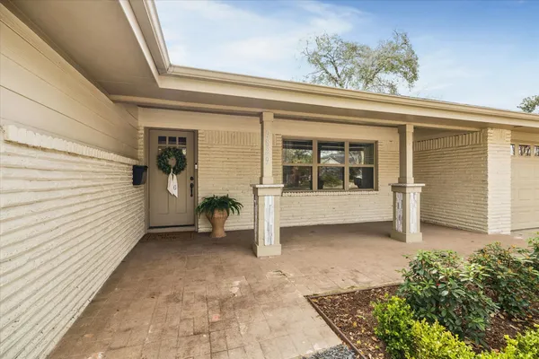a view of a porch with a table and chairs and potted plants