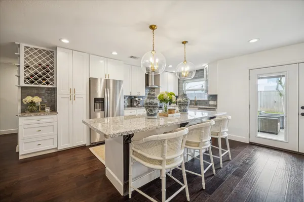 a kitchen with stainless steel appliances kitchen island granite countertop a table and chairs in it