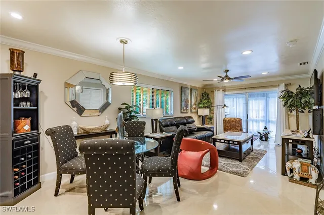 a living room with furniture a rug kitchen view and a chandelier