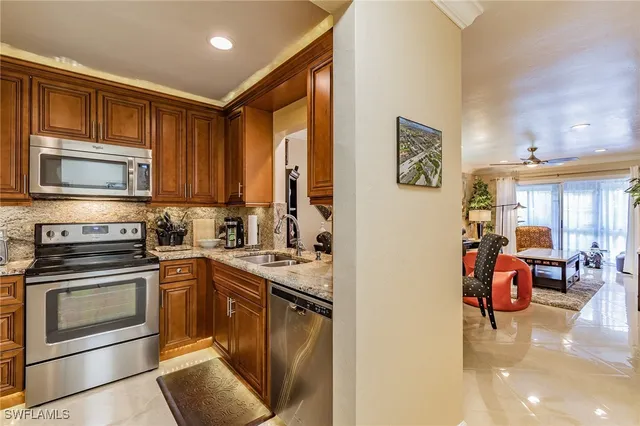 a kitchen with stainless steel appliances granite countertop a stove top oven a sink dishwasher and cabinets with wooden floor