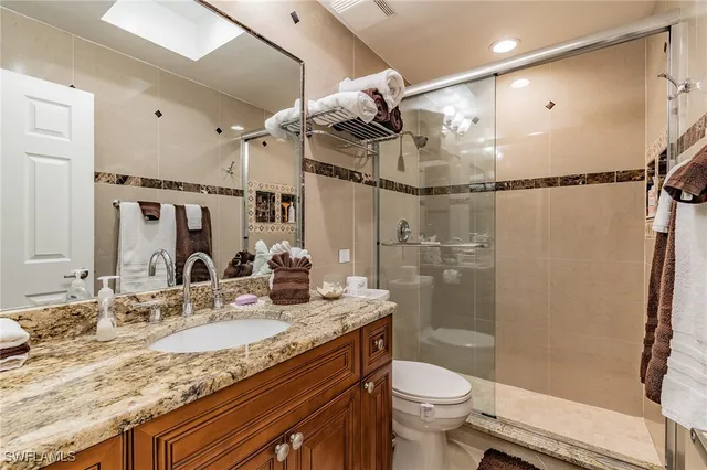 a bathroom with a granite countertop sink toilet and shower