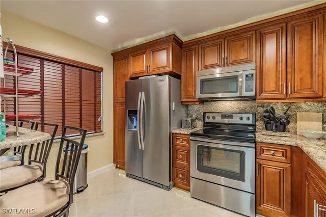 a kitchen with stainless steel appliances granite countertop a refrigerator stove and microwave