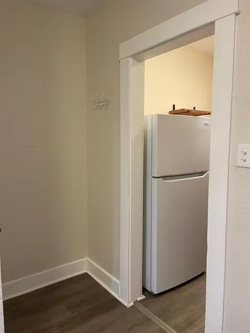 a view of a small space with wooden floor and a window