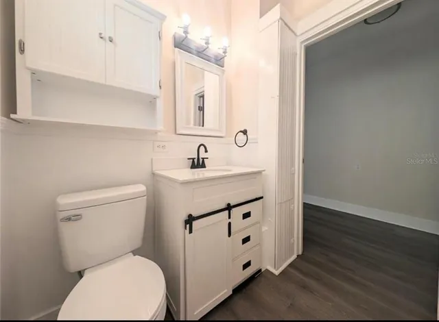 a bathroom with a toilet sink and mirror
