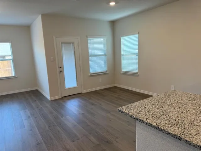 an empty room with wooden floor and window