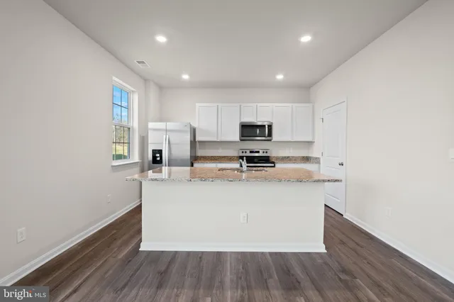 a kitchen with stainless steel appliances granite countertop a refrigerator a stove top oven a sink and dishwasher