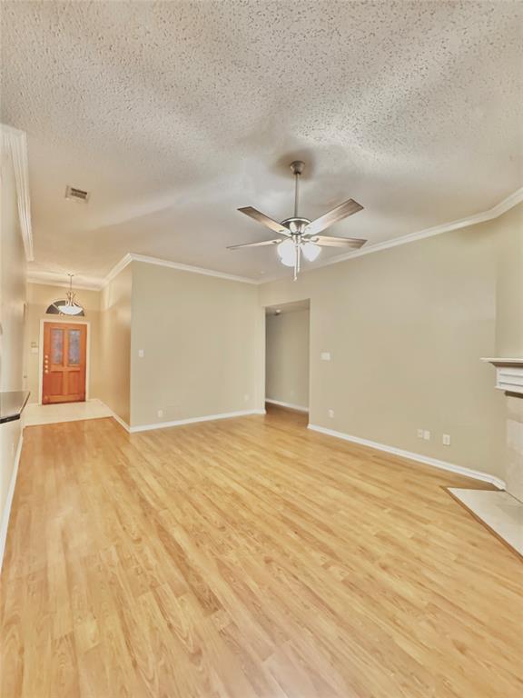 4005 Ridge Rock Drive Plano, TX 75074 - Photo 4 of 13 an empty room with wooden floor fan and windows