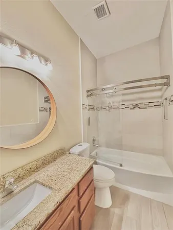 a bathroom with a granite countertop sink a toilet and bathtub