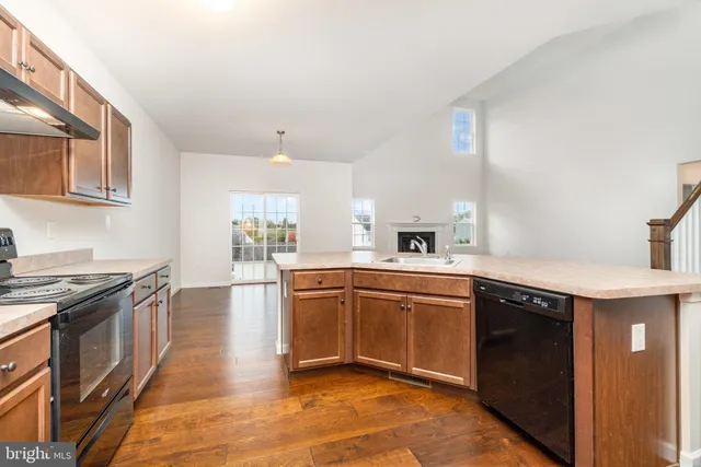 a kitchen with stainless steel appliances granite countertop a stove a sink dishwasher and a refrigerator