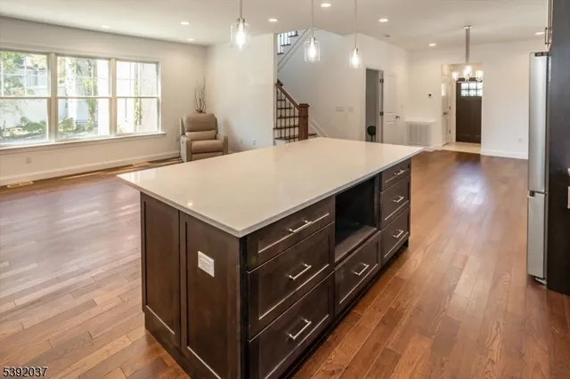 a kitchen with a stove a window and wooden floor
