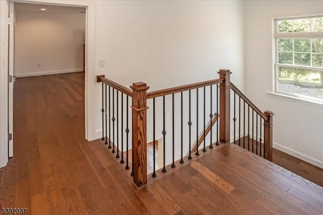 a view of a hallway with wooden floor and a window