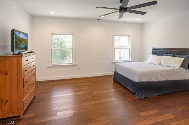 a bedroom with a bed windows and flat screen tv