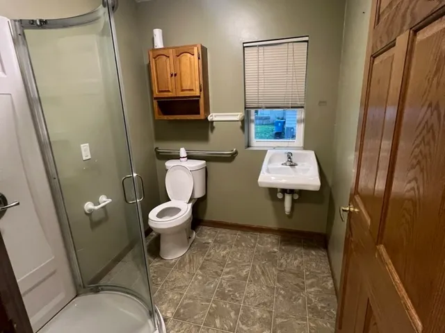 a bathroom with a toilet a sink and mirror