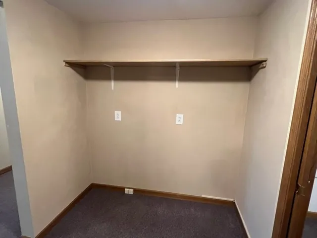 view of a refrigerator in kitchen and an empty room