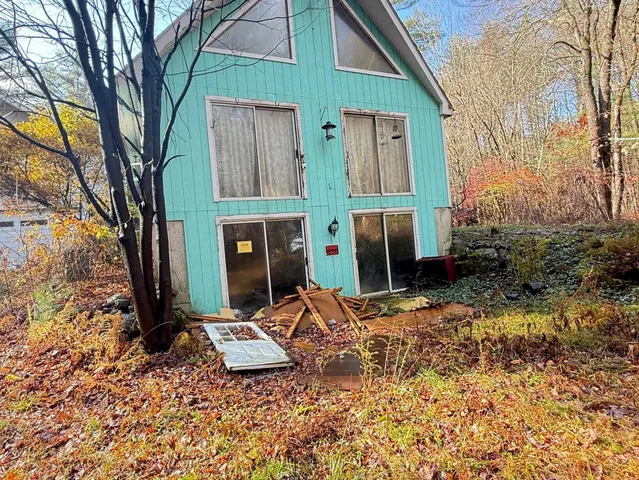 a view of an house with backyard and trees