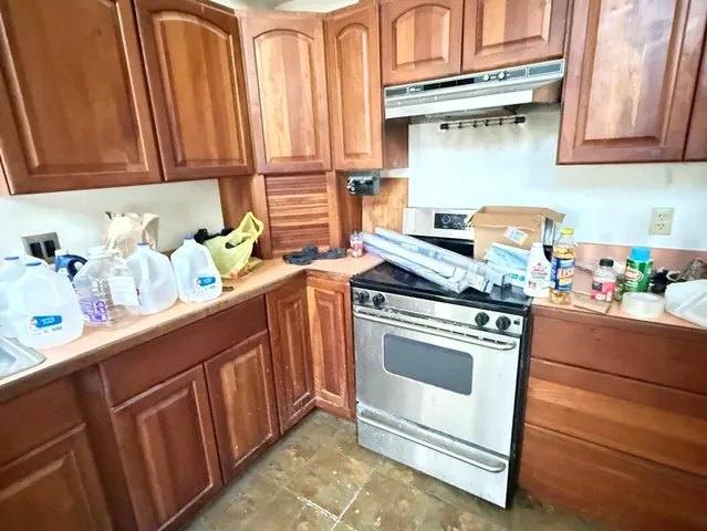 a kitchen with stainless steel appliances granite countertop a sink stove and cabinets